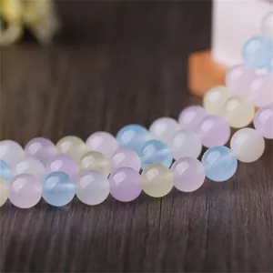 Gros plan de perles rondes en calcédoine morganite aux couleurs acidulées pour bijoux