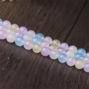 Gros plan détaillé de perles rondes en calcédoine morganite colorées sur bois sombre