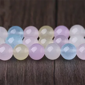 Gros plan montrant la texture lisse des perles de calcédoine Morganite aux tons pastel