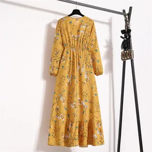 Rückansicht eines gelben Maxikleids aus Chiffon mit Blumenmuster am Ständer