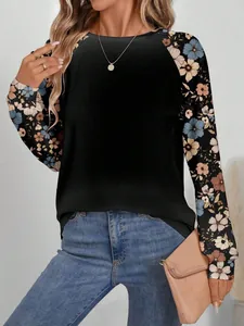 Détails des manches raglan à motif floral et de l'encolure ronde du sweat-shirt noir