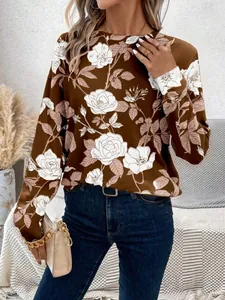 Détail d'un sweat-shirt marron pour femme avec motif floral blanc et col rond