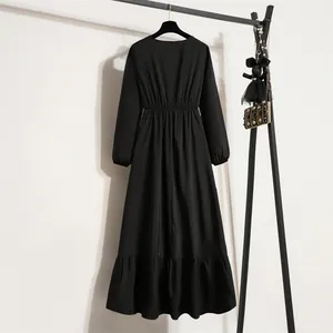 Detailansicht des schwarzen Langarm-Midikleids mit elastischer hoher Taille und Rüschensaum
