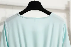 Nahaufnahme des runden Ausschnitts und des hellblauen Chiffonstoffs eines langen Kleides.
