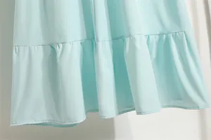 Nahaufnahme eines hellblauen Chiffonkleides mit einem eleganten Volantsaum am Rock.