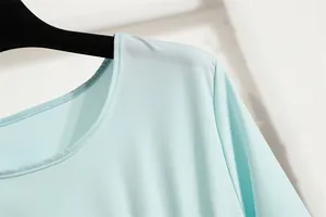 Nahaufnahme des eleganten Rundhalsausschnitts und des glatten Stoffes eines Kleides