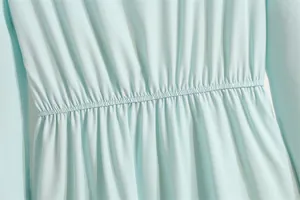 Detailansicht eines hellblauen Chiffonkleides mit hoher elastischer Taille und Falten.
