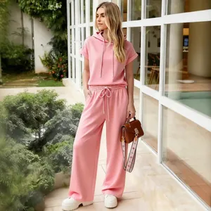 Elegant pink two-piece tracksuit set featuring hooded short-sleeve top and wide-leg pants
