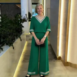 Élégant ensemble deux pièces vert émeraude avec pantalon large et col en V à paillettes.