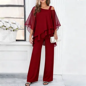 Elegant burgundy two-piece set with asymmetrical tiered top and wide-leg trousers.