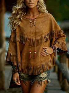 Macro detail of bohemian brown faux suede poncho with fringe layers and lace-up neck.