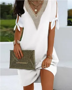 Detailed view of an elegant white summer dress with lace V-neck and split bow tie sleeves