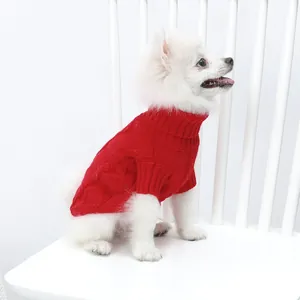 Vue latérale d'un petit chien blanc portant un pull à col roulé rouge en maille torsadée
