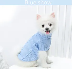 Vue détaillée d'un pull en tricot bleu à col roulé pour animaux sur un petit chien blanc.