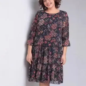Elegante abito a fiori da donna a balze con maniche a volant in tonalità scure.