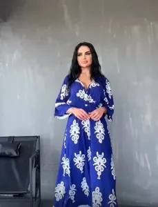 Detailed view of stylish blue bohemian maxi dress with white floral patterns on a model