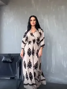 Bohemian style beige maxi dress with intricate black floral embroidery and V-neckline