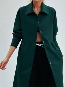 Détail d'une veste chemise mi-longue vert foncé avec un col à revers classique.