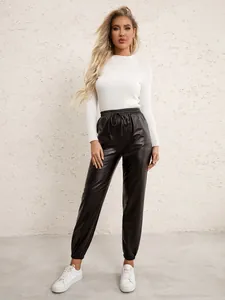 Detail of black PU leather jogger pants with elastic drawstring waist and white rib knit top
