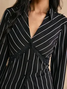 Close-up detail of black and white striped shirt with delicate lace trim and V-neckline