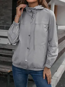 Nahaufnahme einer grauen Damen-Windjacke mit Kapuze und Druckknopfverschluss.