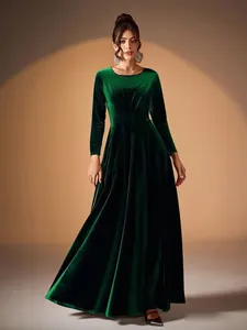 Detail view of an elegant emerald green velvet maxi dress with long sleeves and pleats.