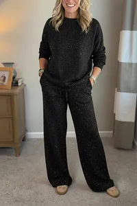 Detail of black sparkly two-piece set featuring a loose sweatshirt and wide-leg pants