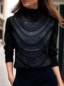 Detail eines schwarzen Langarmtops mit eleganten silbernen Strass-Wellenmuster-Verzierungen.