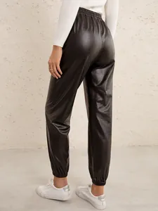 Detailed view of women's black faux leather joggers featuring an elastic high waist and cuffs.