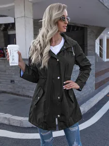 Outdoor full-length view of a mid-length olive green hooded raincoat with zipper for women