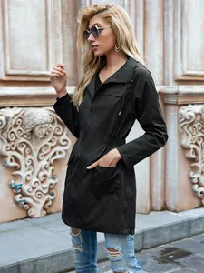 Vista laterale di un impermeabile nero da donna con cappuccio, coulisse e tasche