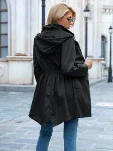 Vista posteriore di una giacca impermeabile nera da donna con cappuccio e vita con coulisse.