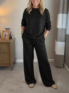 Detailed view of women's black glitter sweatshirt and wide-leg pants fashion set.