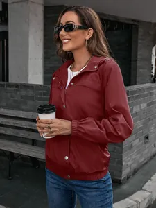 Außenansicht einer Frau in einer weinroten Windjacke mit Kapuze und Reißverschluss.
