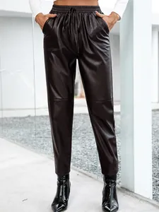 Détail d'un pantalon en similicuir avec taille élastique à cordon et poches latérales.