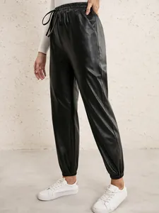 Close-up view of women's black faux leather joggers with elastic drawstring waist detail.