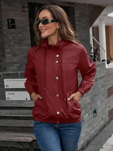 Detailaufnahme des weinroten Windbreakers mit Kapuze, silbernen Druckknöpfen und Kordelzug