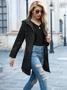 Vista di una donna con un impermeabile nero con cappuccio in una classica strada urbana