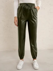 Detail view of dark green PU leather joggers with drawstring waist and cuffed ankles