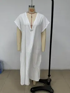 Detailed view of white cotton linen maxi dress featuring delicate lace trim on the V-neckline