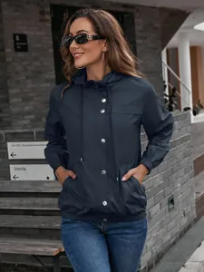 Nahaufnahme der dunkelblauen Damen-Windjacke mit Kapuze, wasserdicht und Metallknöpfen.