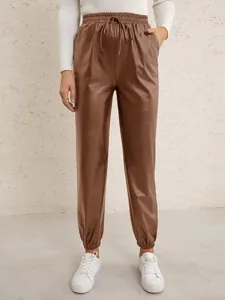 Close-up detail of women's brown PU leather joggers with elastic drawstring waist and cuffs.
