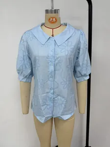 Détail d'une chemise bleu clair à manches courtes avec broderie florale élégante