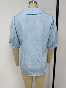 Vue arrière d'un chemisier bleu clair avec broderie florale et manches courtes