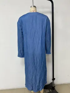 Back view of a long-sleeved blue faux denim dress on a mannequin with loose fit.