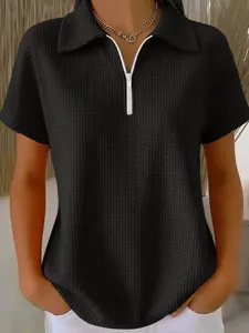 Vue détaillée du polo en maille gaufrée noire avec demi-fermeture éclair élégante.
