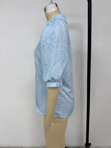 Vue latérale détaillée d'une chemise bleu clair avec broderie florale sur un mannequin