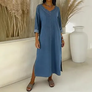 Full-length view of a casual loose V-neck denim maxi dress featuring side slits