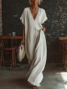 Detail view of an elegant V-neck linen maxi dress with delicate lace trim embroidery