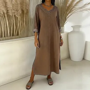 Detail view of a loose V-neck brown faux denim maxi dress with side slits on a model.